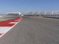 an empty track at a motorsports club with some red and white stripeing on it