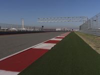 an empty track at a motorsports club with some red and white stripeing on it