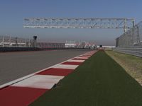 an empty track at a motorsports club with some red and white stripeing on it