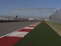 an empty track at a motorsports club with some red and white stripeing on it