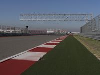 an empty track at a motorsports club with some red and white stripeing on it