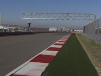 an empty track at a motorsports club with some red and white stripeing on it