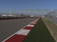 an empty track at a motorsports club with some red and white stripeing on it