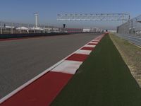 an empty track at a motorsports club with some red and white stripeing on it