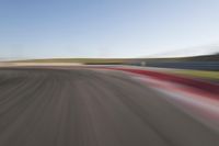 view of a car moving in a fast pace across the tarmac of a track