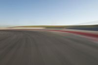 view of a car moving in a fast pace across the tarmac of a track