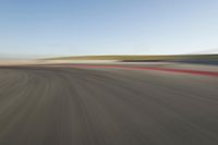 view of a car moving in a fast pace across the tarmac of a track