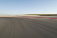 view of a car moving in a fast pace across the tarmac of a track