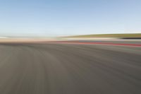 view of a car moving in a fast pace across the tarmac of a track