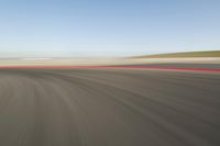 view of a car moving in a fast pace across the tarmac of a track