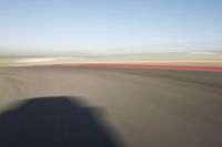 view of a car moving in a fast pace across the tarmac of a track