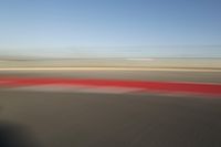 view of a car moving in a fast pace across the tarmac of a track