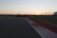 blurred speed - moving image of a race track at sunset with red and white stripes