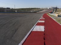 an empty track at a motorsports club with some red and white stripeing on it