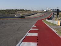 an empty track at a motorsports club with some red and white stripeing on it