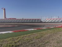 an empty track at a motorsports club with some red and white stripeing on it