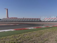 an empty track at a motorsports club with some red and white stripeing on it