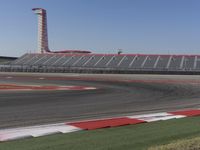 an empty track at a motorsports club with some red and white stripeing on it