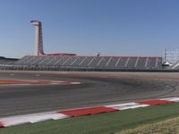 an empty track at a motorsports club with some red and white stripeing on it