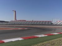 an empty track at a motorsports club with some red and white stripeing on it