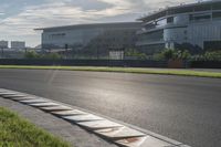 a motorcycle with a rear wheel is parked at a race track near buildings in the background