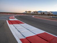 a photo of a dirt race track with sun setting in the distance of the track