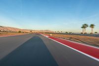 a photo of a dirt race track with sun setting in the distance of the track