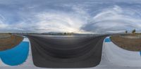 a panoramic view of a road covered in a tarp as the sun shines through