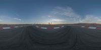 a long, wide circular panoramic view of a track in the sunset with clouds