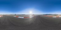 a 360 - 360 panoramic view of some races with sun in background and sky