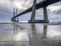 the bridge is standing in the rain as it rains over the ground with graffiti on the floor