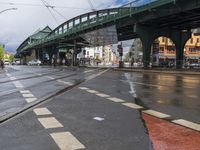 a bridge crossing over a street filled with traffic on a rainy day in the city