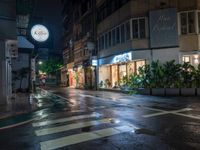 wet street on a rainy evening with traffic passing by at night, lit up by shop signs