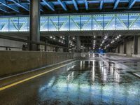 people waiting for a train to arrive at the station as it is raining down on