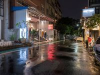 rain on the street in an urban setting at night time with neon signs that read, no parking