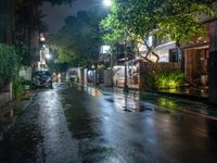 an empty street with rain on the side and cars parked on either side of it