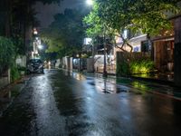 an empty street with rain on the side and cars parked on either side of it