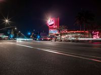 a sign and cars parked outside the building that looks like the hotel called red barn in las angeles