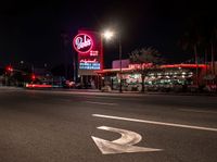 a sign and cars parked outside the building that looks like the hotel called red barn in las angeles