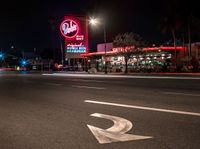 a sign and cars parked outside the building that looks like the hotel called red barn in las angeles