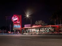 a sign and cars parked outside the building that looks like the hotel called red barn in las angeles