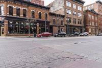 a group of cars parked outside a red brick building and a red car in front of it