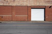 there is an outside of a red brick building with an open garage door and fire hydrant