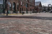 a building that has people walking on the sidewalk in front of it is red bricks