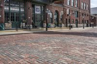 a building that has people walking on the sidewalk in front of it is red bricks