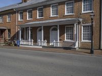 the buildings are red brick and the porchs are white railings and windows are empty