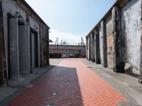 a red brick walkway on the side of an alley way with old buildings and doors