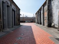 a red brick walkway on the side of an alley way with old buildings and doors