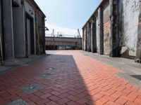 a red brick walkway on the side of an alley way with old buildings and doors