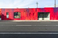 red building with graffiti on the wall next to a street with two fire hydrants